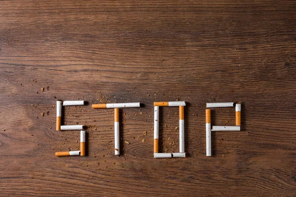 Fondo Creativo Palabra Stop Compone Cigarrillos Sobre Fondo Madera Marrón —  Fotos de Stock