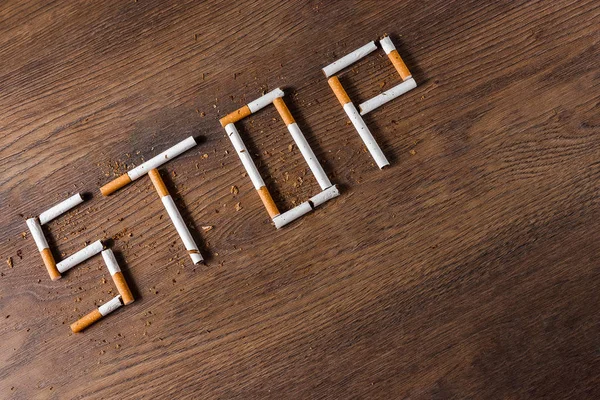 Fondo Creativo Palabra Stop Compone Cigarrillos Sobre Fondo Madera Marrón — Foto de Stock