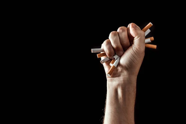 Fondo creativo, mano masculina aprieta un puño de un cigarrillo. El concepto de fumar mata, deja de fumar. Copiar espacio . — Foto de Stock