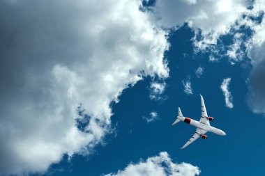 Mavi gökyüzü ve kabarık bulutlar karşı uçak. Tatil, tatil, uçak, seyahat kavramı.