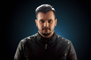 Genç adam, siyah arka planda, yakın plan portresi