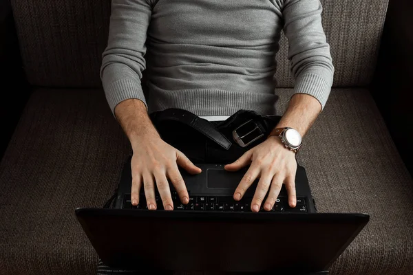 Młody Człowiek Pracujący Laptopie Relaksując Się Wygodnej Kanapie Domu Dżinsach — Zdjęcie stockowe