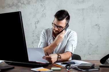 Bir adam, ofiste bir masada oturan, telefonla konuşan bir adam önemli bir soruya karar verir. Ofis işi kavramı, bir başlangıç. Boşluğu kopyala.