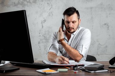 Bir adam, ofiste bir masada oturan, telefonla konuşan bir adam önemli bir soruya karar verir. Ofis işi kavramı, bir başlangıç. Boşluğu kopyala.