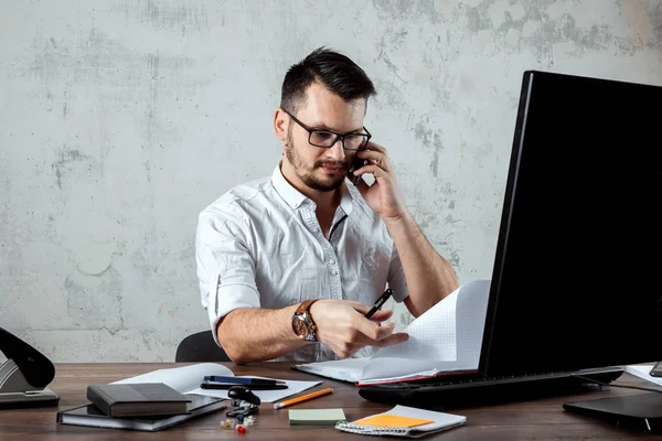 Bir adam, ofiste bir masada oturan, telefonla konuşan bir adam önemli bir soruya karar verir. Ofis işi kavramı, bir başlangıç. Boşluğu kopyala.