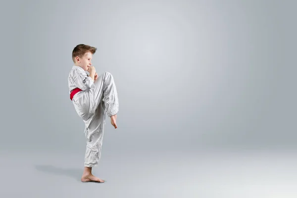 Creative Background Child White Kimono Makes Kick Light Background Concept — Stock Photo, Image