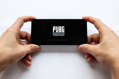 Brest, Belarus, 22 Ocak 2019. Erkek eller Pubg Fps oyunu ile akıllı telefon tutarak. savaş oyun logo. Yumuşak odak.