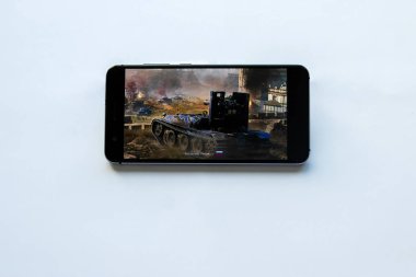 Brest, Belarus, 22 Ocak 2019. Dünya Tanks oyunu ile akıllı telefon tutarak erkek eller. Tank oyun logo dünyası. Yumuşak odak.