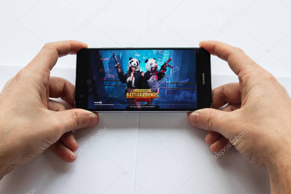 Brest, Belarus, January 22, 2019. Closeup male hands holding smartphone with PUBG FPS game. battleground game logo. Soft focus.