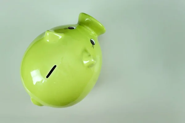 Creative background, green pig money box on gray background top view, flat lay. The concept of saving money, savings, pig piggy, family budget, copy space.