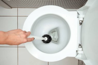 Yakın çekim, tuvalet fırçası el yıkar. Temizlik ev, hijyen, tuvalet, mikroplar kavramı.