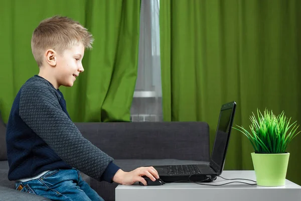 A boy at a laptop plays games, or watches a video. The concept of addiction to computer games, blurred vision, district mental health. copy space