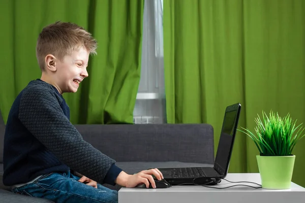 A boy at a laptop plays games, or watches a video. The concept of addiction to computer games, blurred vision, district mental health. copy space