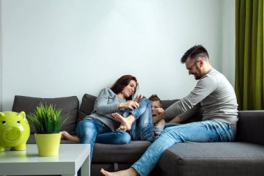 Mutlu anne ve eğleniyor, birlikte gülüyoruz, oğulları, aile eğlenceli bir oyun oynuyor Çift kanepede oturan gıdıklıyor oğlu.