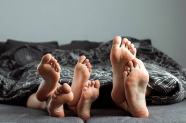 Mutlu aile, yakın çekim bacaklar battaniyenin altından çıkmış. Uzay kopyalayın. Aile, aile ilişkileri, başarılı bir evlilik kavramı.
