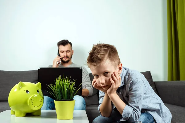 Sad Boy Looks Camera While His Father Works Background Home — Stock Photo, Image