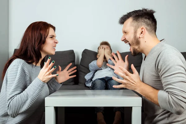 Family quarrel, poma and dad swear in the background of the son who does not like it, the child cries. The concept of family problems, the psyche of the child, domestic violence.