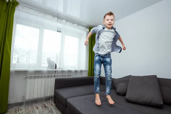 Menino Pula Sofá Sala Estar Divertindo Brincando Enquanto Seus Pais — Fotografia de Stock