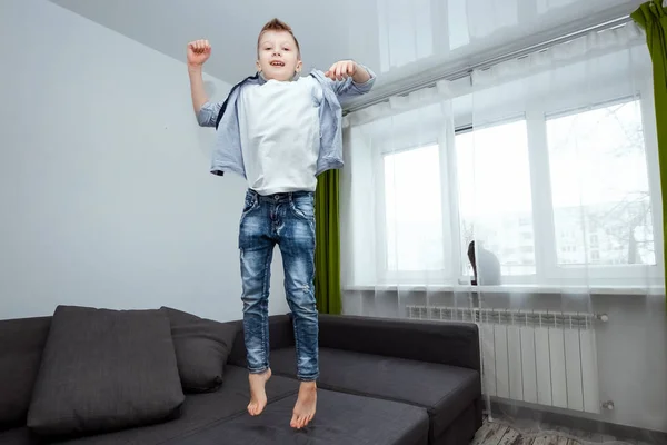 Menino Pula Sofá Sala Estar Divertindo Brincando Enquanto Seus Pais — Fotografia de Stock