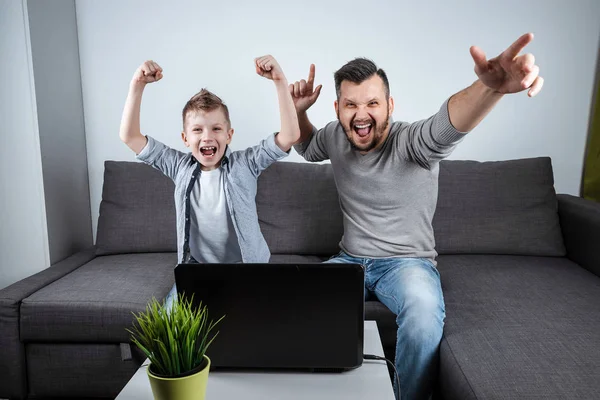 父子们在家里用笔记本电脑看足球 情感的男人和男孩 欢呼最喜欢的球队 家庭热情 家庭时间 复制空间的概念 — 图库照片