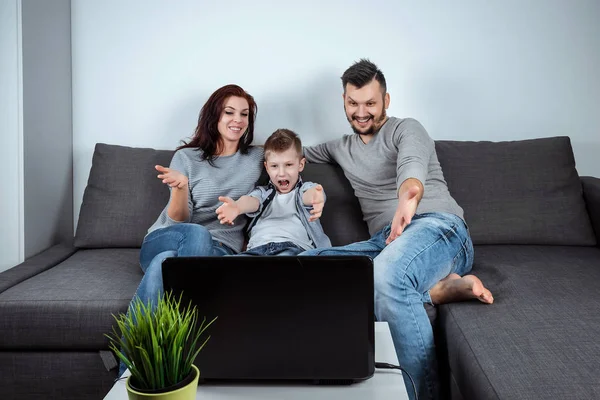 一个幸福的家庭 微笑着看着笔记本电脑里的东西 共同消遣 共同休息 家庭关系的概念 — 图库照片