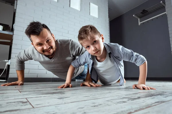 Sports family, father and son wrung out together, go in for sports. The concept of sports since childhood, a healthy lifestyle, a healthy family.