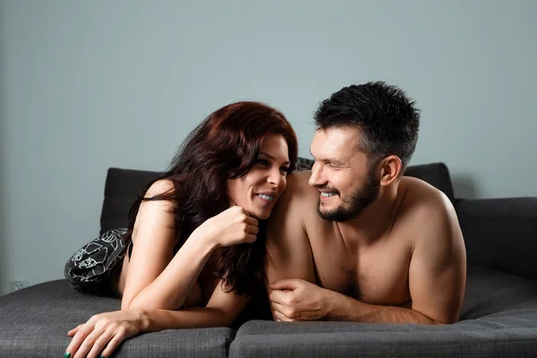 Joyeux couple couché sous les couvertures. Le concept de sexe, relations saines, désir sexuel . — Photo