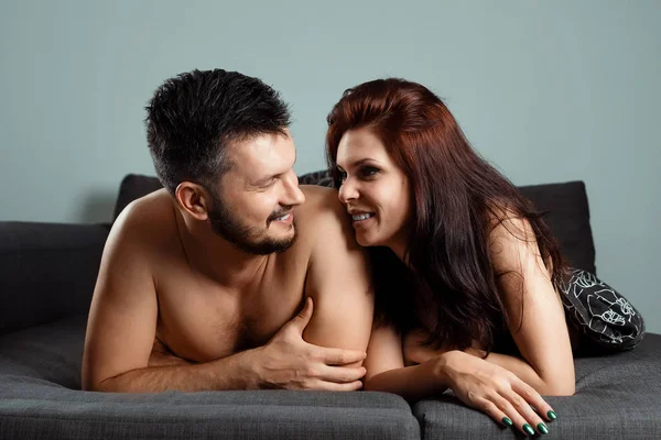 Joyeux couple couché sous les couvertures. Le concept de sexe, relations saines, désir sexuel . — Photo