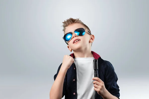 Retrato de un chico guapo sobre un fondo gris. El chico con gafas oscuras . —  Fotos de Stock