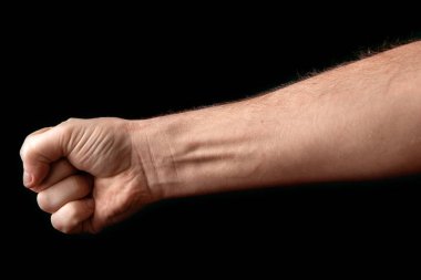 Yumruk siyah arka planda izole. Güçlü bir adam, siyah bir arka plan, güç, protesto, yumruk savaşa hazır yumruk kaldırdı.