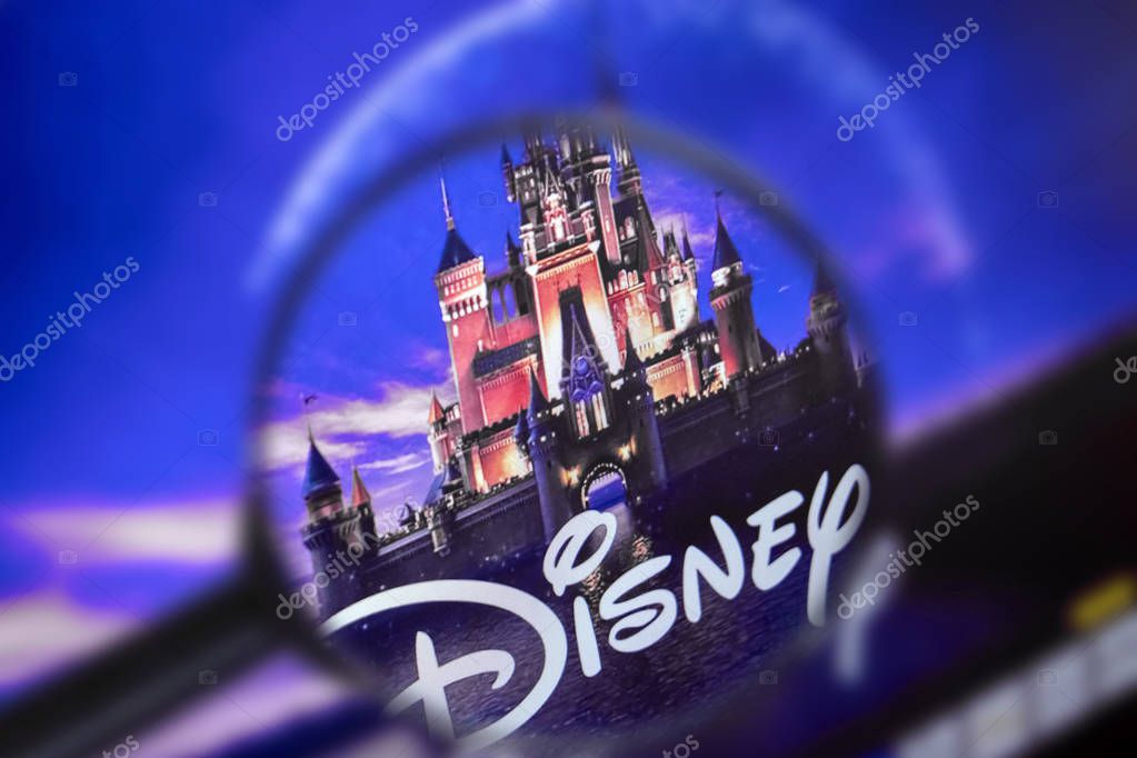 Brest, Belarus, March 15, 2019. The home page of the Disney site, view through a magnifying glass. Disney company logo is visible. Soft focus.
