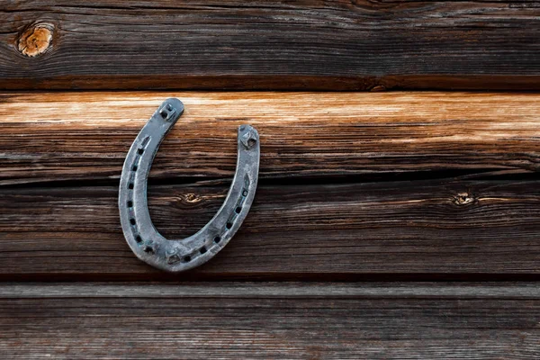 Una vieja herradura sobre una vieja tabla de madera. El concepto de suerte, suerte, suerte . — Foto de Stock