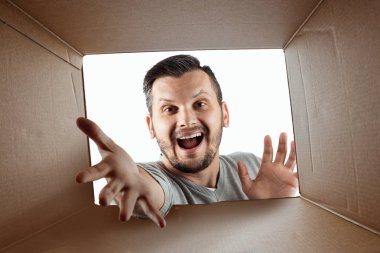 Unboxing, Yaratıcı arka plan, neşeli adam kutusunu açar ve sürpriz görünüyor. Paket, teslimat, sürpriz, hediye