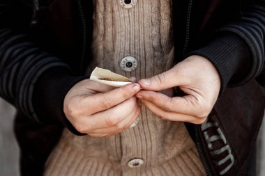 Sigara içen bir adamın elleri. Esrar, uyuşturucu, bağımlılık kavramı.