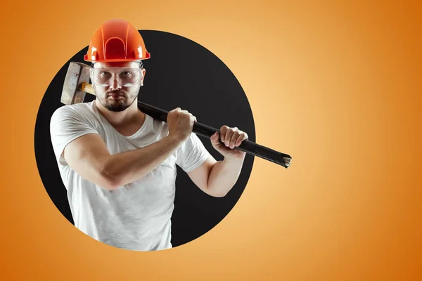 Bearded Man in een helm houdt een Sledgehammer op een oranje achtergrond. Concept bouw, aannemer, herstelling. — Stockfoto