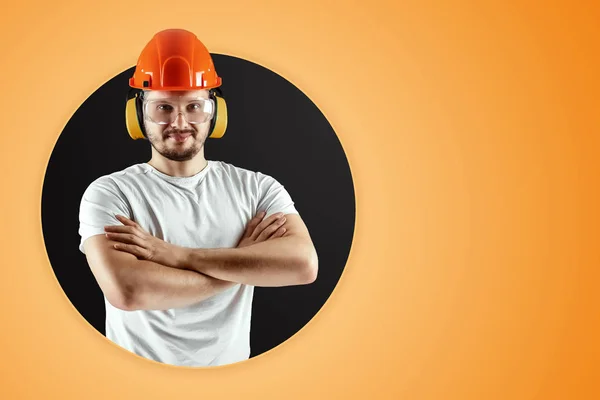 Mužský tvůrce v oranžové přilbě na oranžovém pozadí. Koncept stavby, zhotovitele, opravy. — Stock fotografie