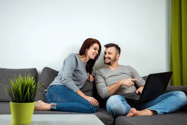 La muchacha y el muchacho se divierten en dos para el portátil. El concepto de relaciones familiares, ver películas juntos, compartir tiempo . —  Fotos de Stock