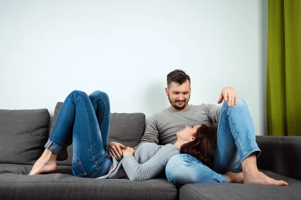 Una pareja cariñosa tendida en una cama en casa, una familia perezosa descansando el fin de semana. Relaciones familiares, amor . —  Fotos de Stock