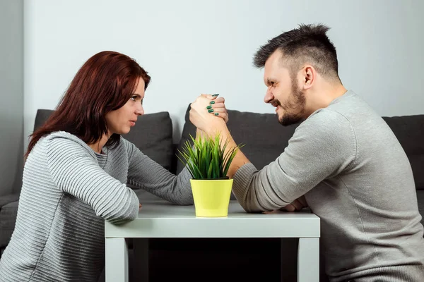 Husband and wife are fighting in their arms, arm wrestling between male and female. Family quarrel, showdown, division of property, divorce. The struggle between women and men.