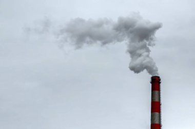 Dumanın gri gökyüzüne değdiği boru. Hava kirliliği, CO2, karbondioksit gazı, egzoz gazı kavramı.