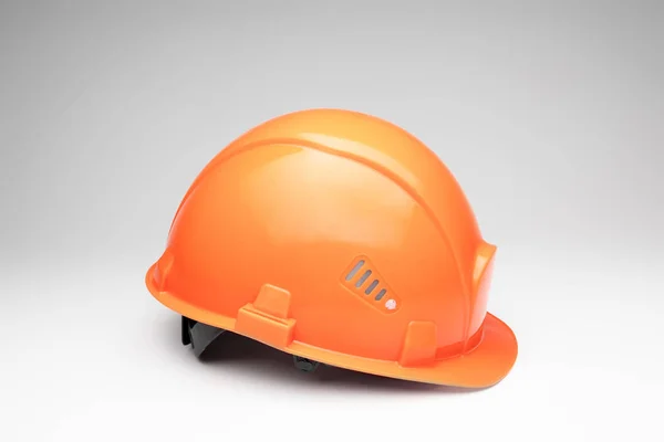Orange construction helmet on a light background. The concept of architecture, construction, engineering, design. Copy space. — Stock Photo, Image
