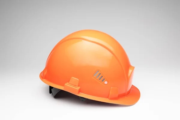 Casco da costruzione arancione su sfondo chiaro. Il concetto di architettura, costruzione, ingegneria, design. Copia spazio . — Foto Stock