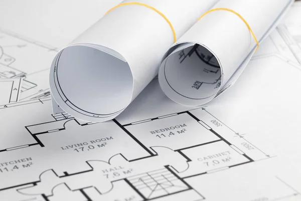 Dibujos arquitectónicos de construcción retorcidos en un rollo, proyectos de construcción sobre papel. El concepto de arquitectura, construcción, ingeniería. Copiar espacio . Fotos De Stock Sin Royalties Gratis