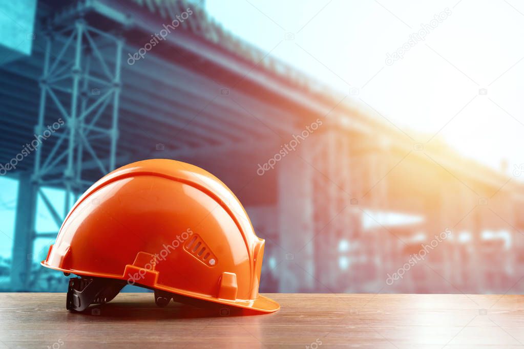 Orangeconstruction helmet close-up on the background of construction. The concept of architecture, construction, engineering, design. Copy space.