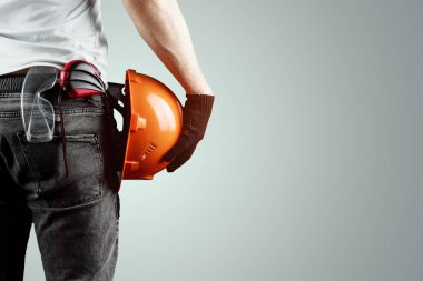 Müteahhit, mimar elinde hafif bir arka plan üzerinde bir inşaat kask tutar, bir bant ölçüsü. Konsept mimarlık, inşaat, mühendislik, tasarım, onarım. Kopyalama alanı