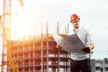 Müteahhit, mimar elinde şantiye nin arka planında mimari çizimler tutar. Konsept mimarlık, inşaat, mühendislik, tasarım, onarım. Kopyalama alanı