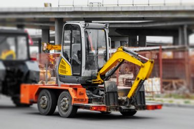 inşaat ekipmanları, bir römork üzerinde küçük bir ekskavatör taşıma. Teslimat, nakliye.