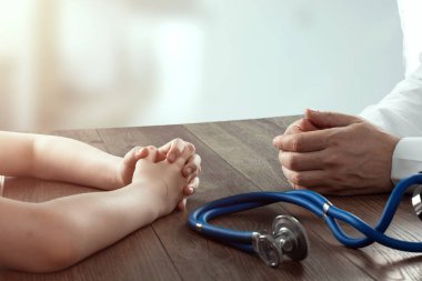Çocuğun elleri ve doktorun yakın çekim, doktor resepsiyon. Tıp kavramı, doktor randevusu, sağlık hizmetleri. Kopyalama alanı.