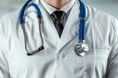 Bir adam, steteskoplu beyaz önlüklü bir doktor. Tıp kavramı, doktor randevusu, sağlık hizmetleri. Kopyalama alanı.