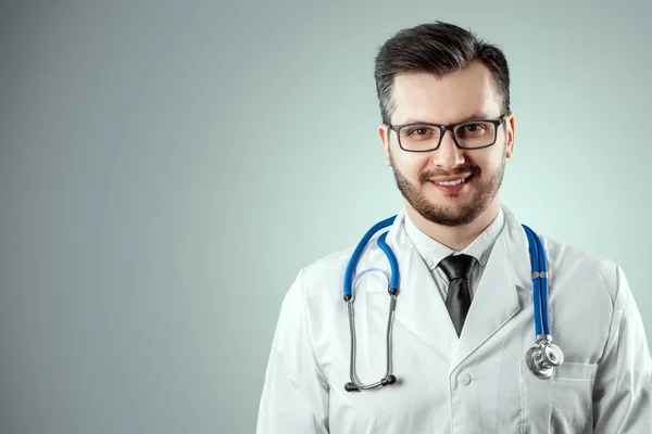 Ein Mann, ein Arzt im weißen Kittel mit Stethoskop. das Konzept der Medizin, ein Arzttermin, Gesundheitsfürsorge. Kopierraum. — Stockfoto